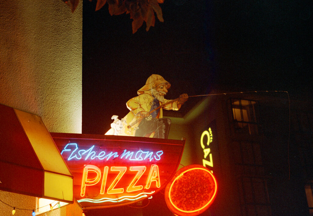 Neon "Fisherman's Pizza" sign at night